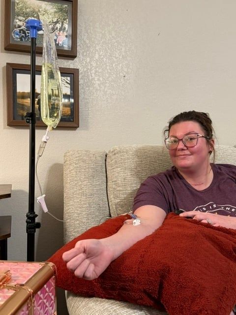 Client receiving vitamin IV therapy on a sofa at home